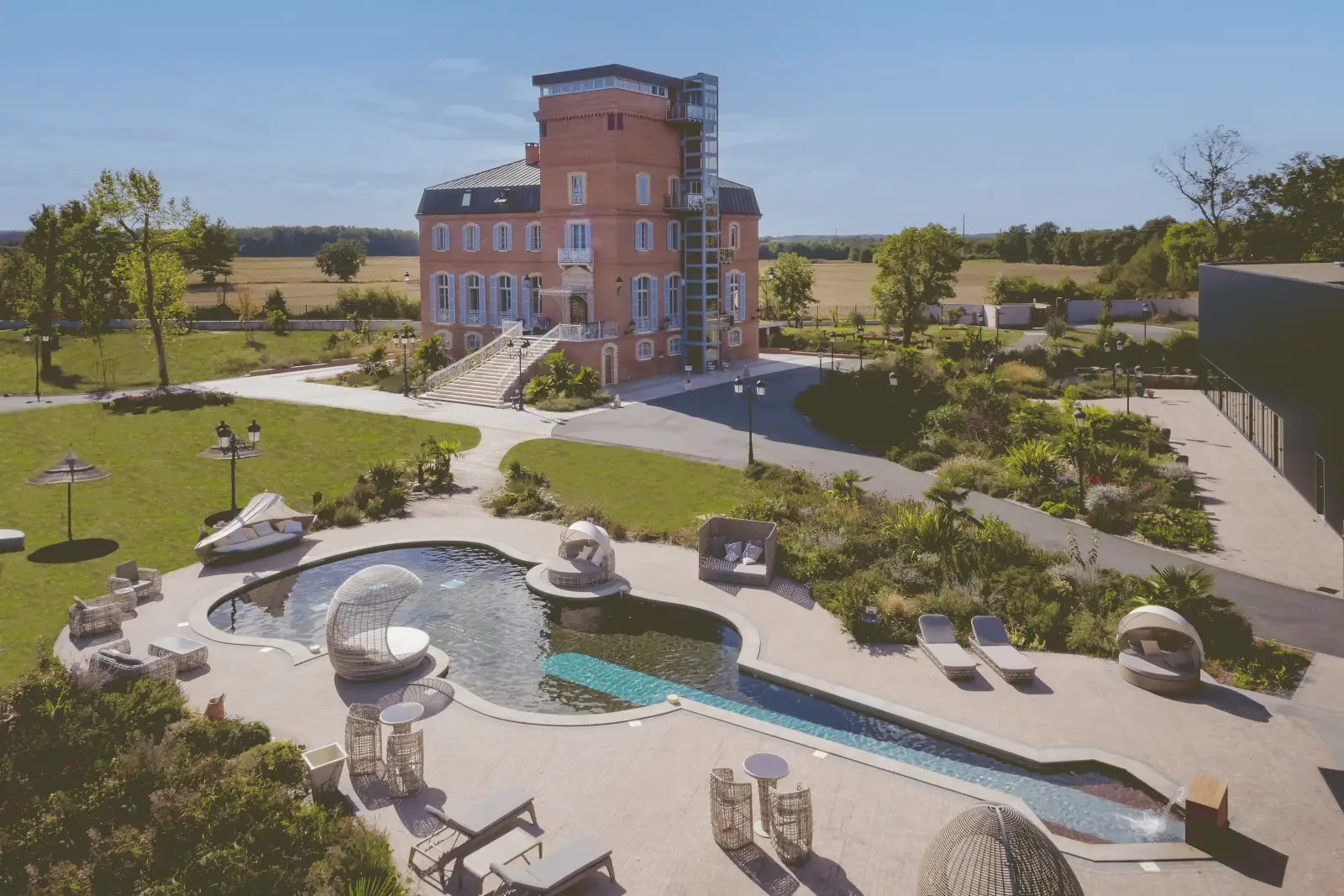 Le Château de la Garrigue vu du ciel, avec sa piscine en forme de violon et ses terrasses